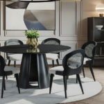 Ambiente sofisticado com mesa redonda preta e cadeiras Jade da Matrezan em madeira, palhinha natural e assento estofado, ideal para salas de jantar elegantes.